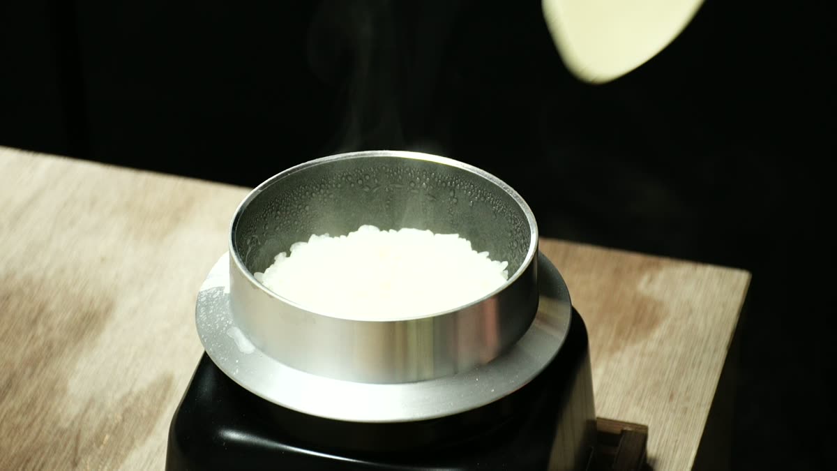 釜の炊きあがり。しゃもじで白米をすくう