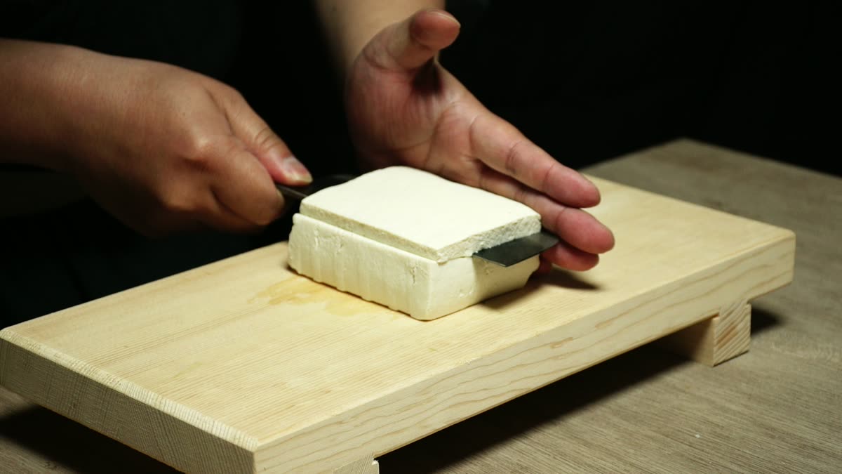 まな板の上で豆腐をうどん状に切る