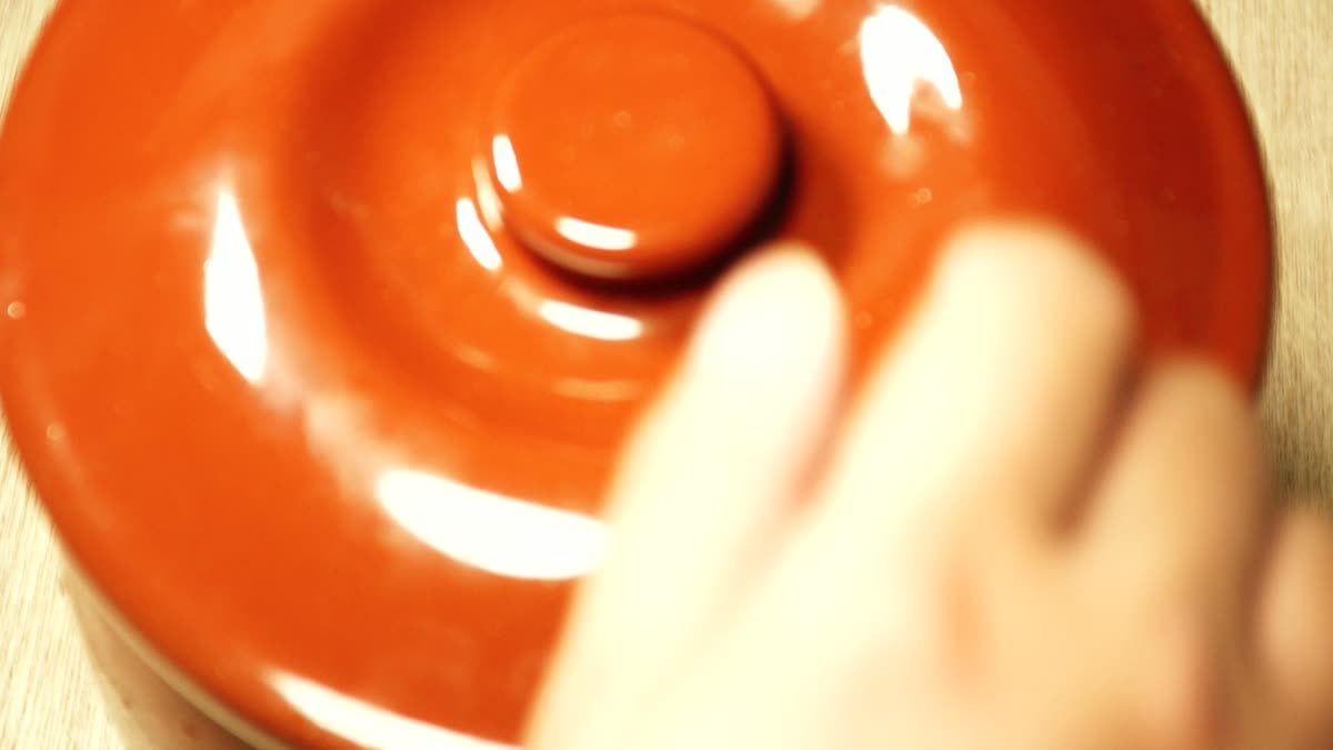 壺の蓋を開けて梅干しを取り出す