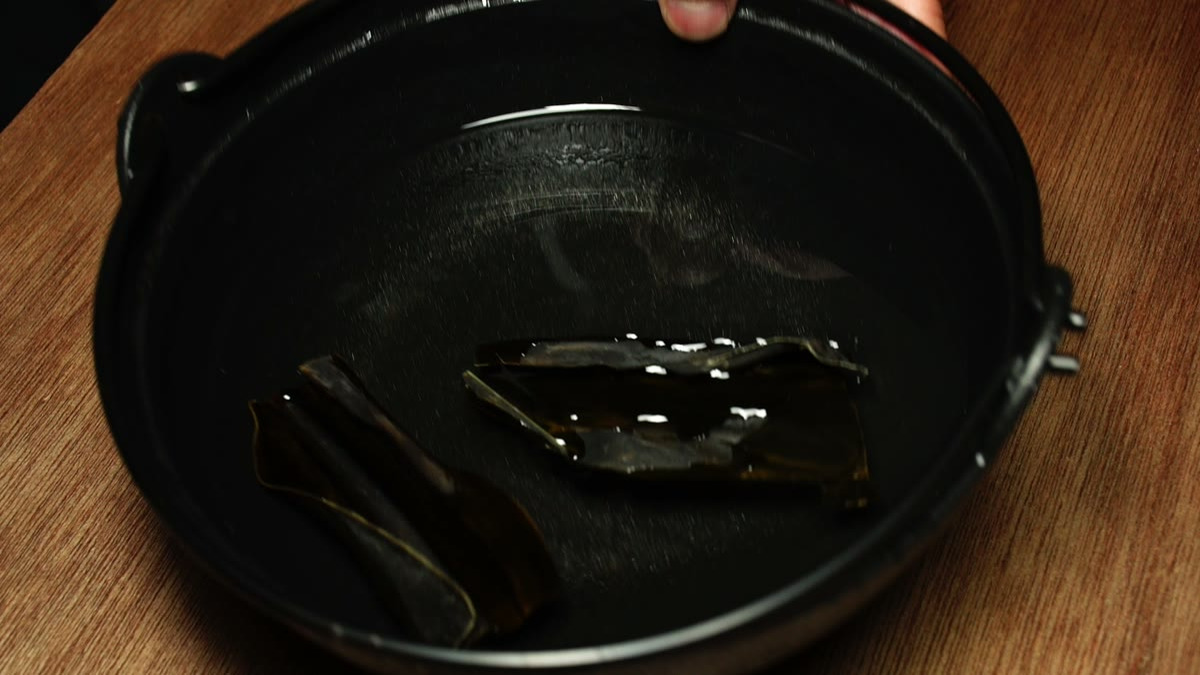 鉄鍋に張った水に昆布を二枚つけているところ