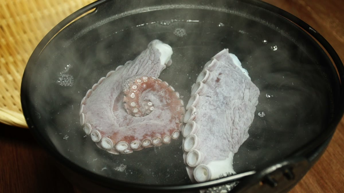 湯気の立つ鍋の中でタコが茹だっているところ