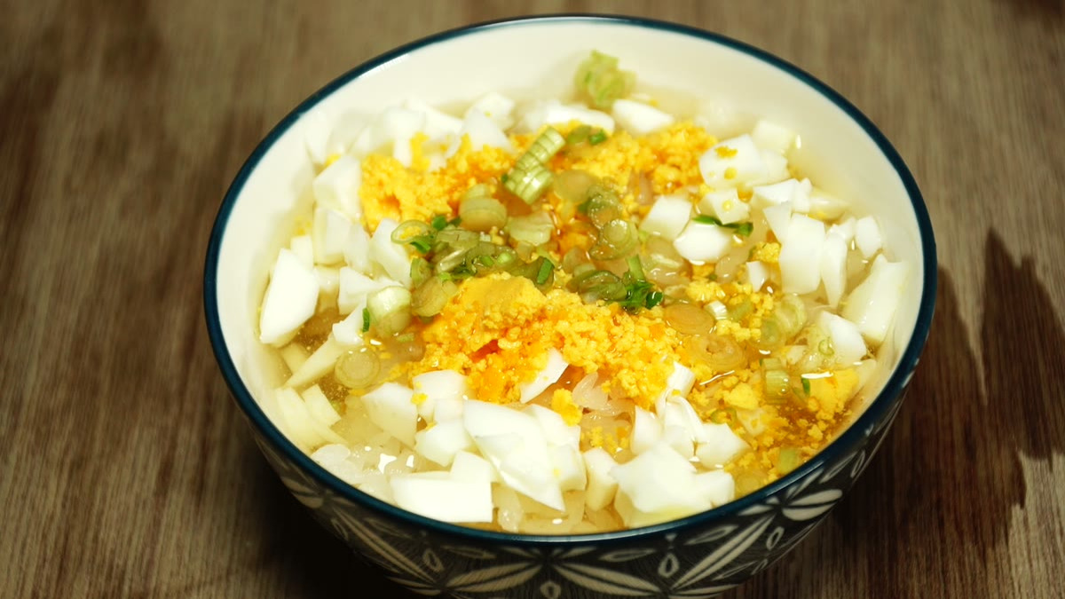飯の中央にうらごしした卵の黄身とせりをのせ、出汁を張った山吹飯