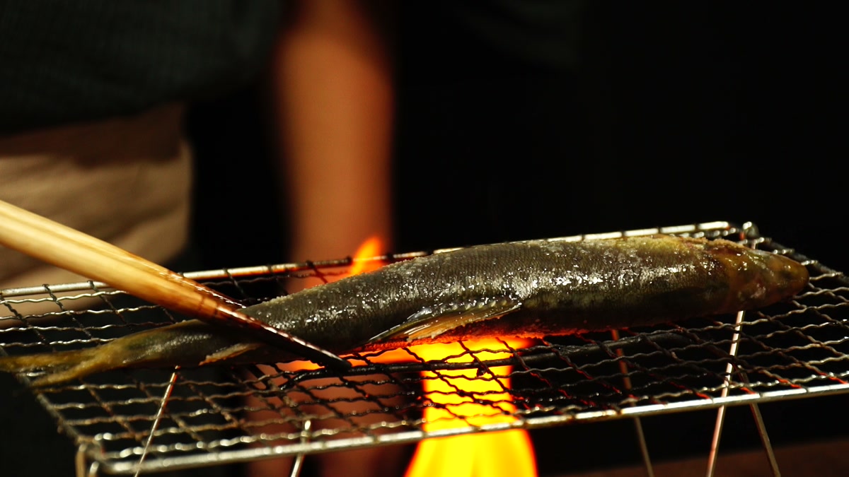 炎の上に渡した焼き網で鮎を焼いているところ