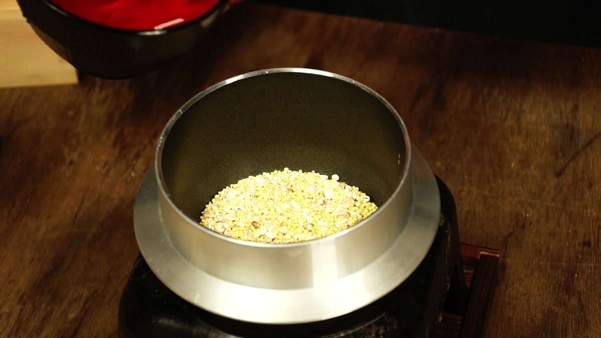 羽釜の底に、乾いた雑穀が薄く広がっている