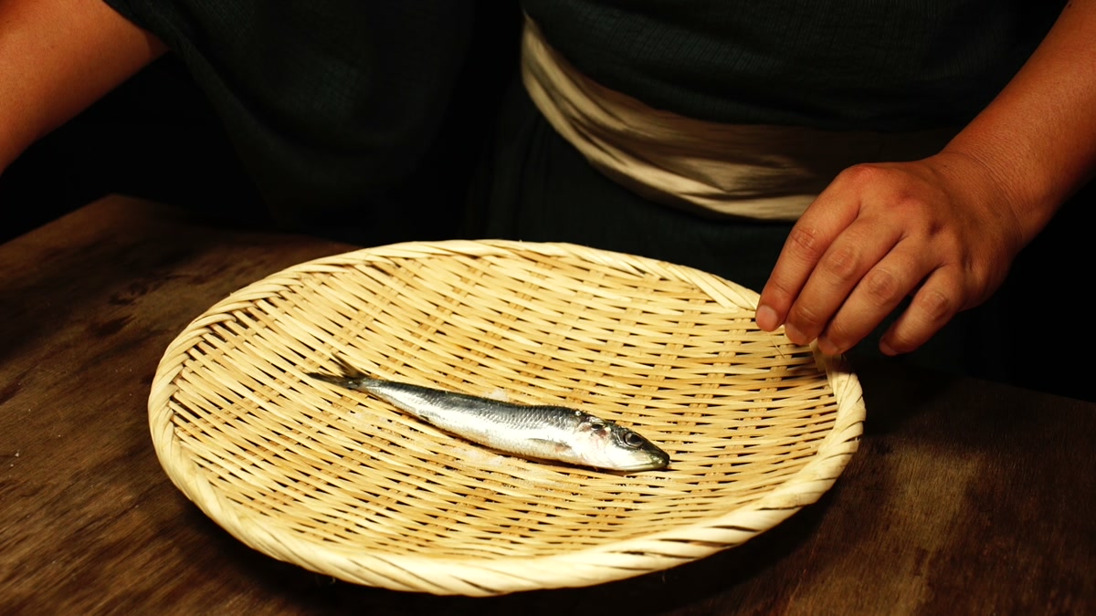 竹ざるの上に鰯を一尾のせているところ