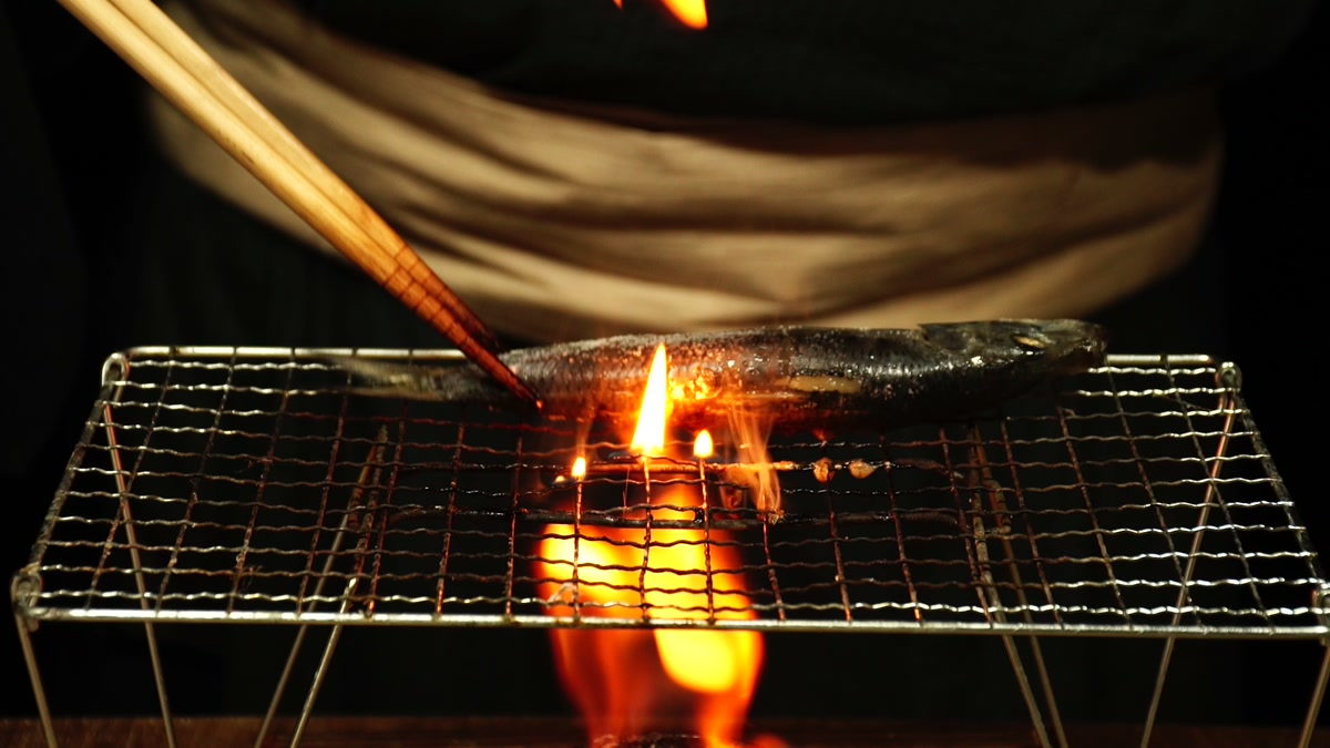 炎の上に渡した焼き網で鰯を焼いているところ