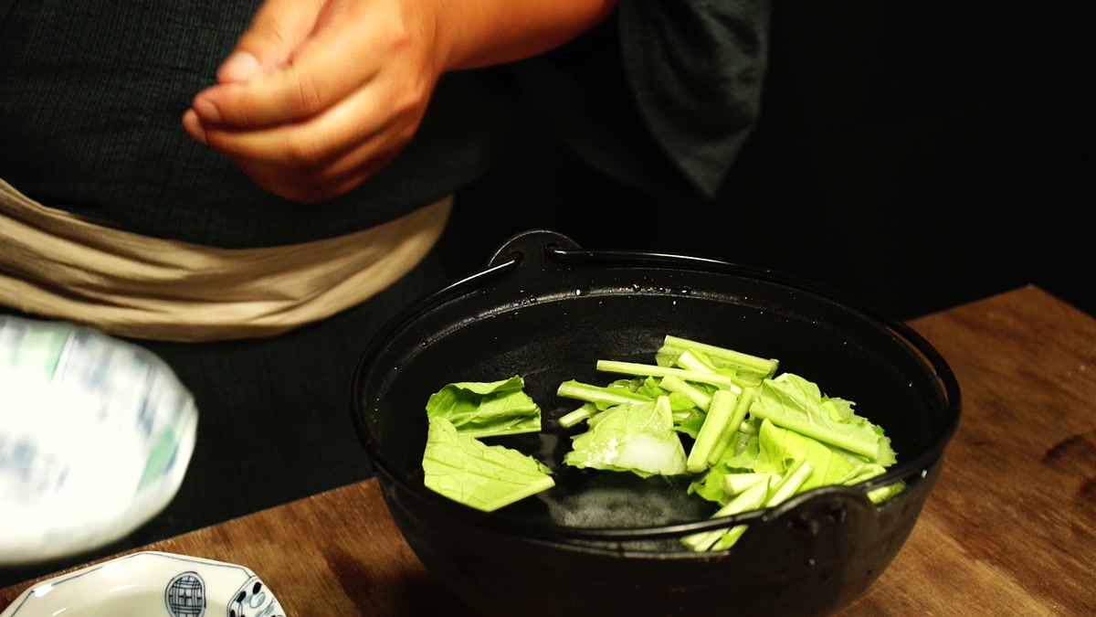 鍋の湯の中に、切った蕪の葉と茎が入っている
