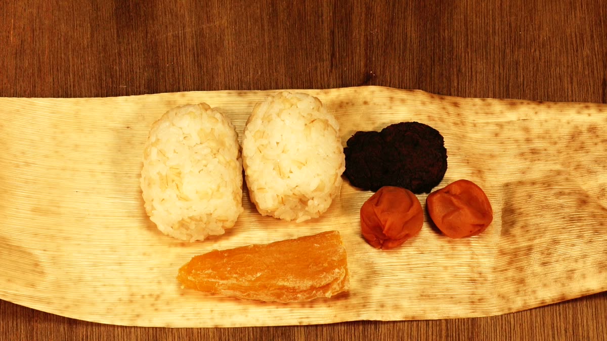 竹の皮に包まれた握り飯、焼き味噌、梅干し、干し芋