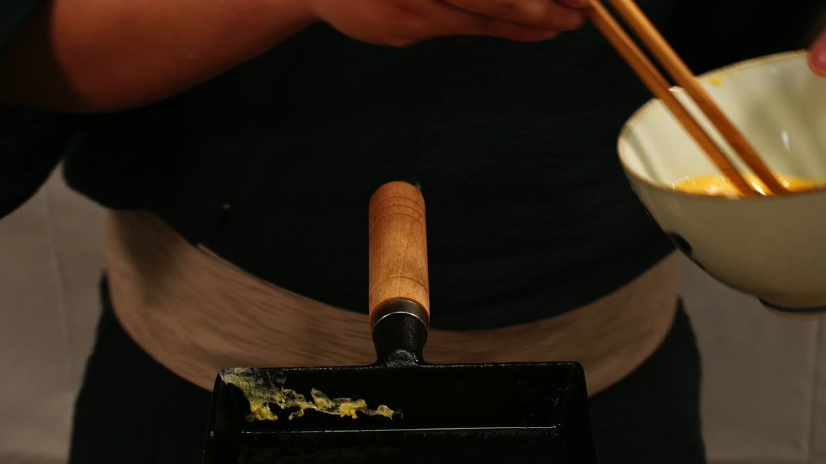 銅の卵焼き器で厚焼き玉子を焼くところ