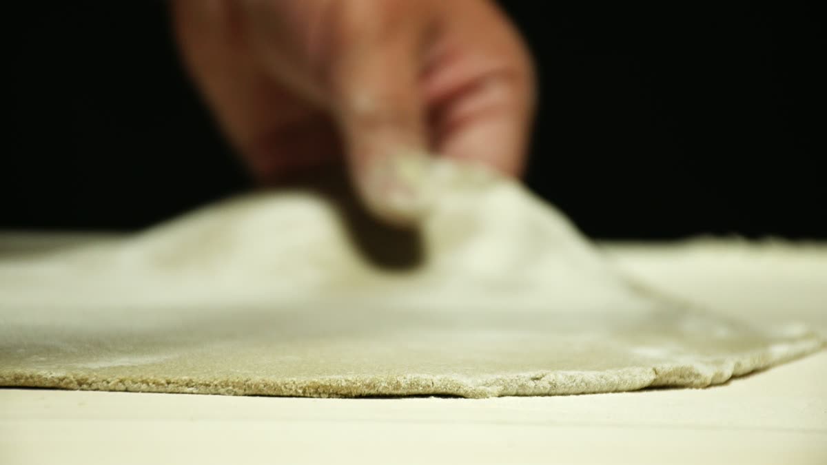 麺棒でそば生地を薄く伸ばす