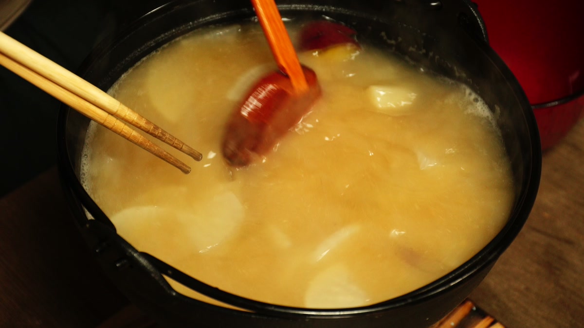 大根とサツマイモが煮えた鍋に、味噌を溶き入れているところ