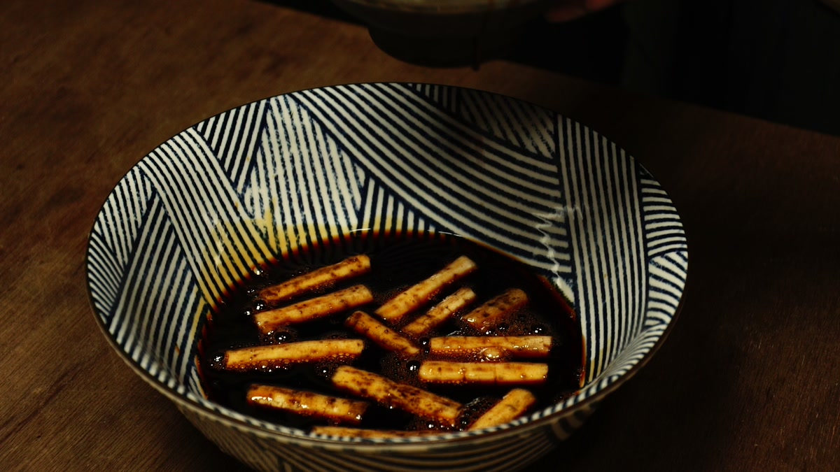 縞模様の鉢に張った醤油に、切った牛蒡を漬け込んだところ
