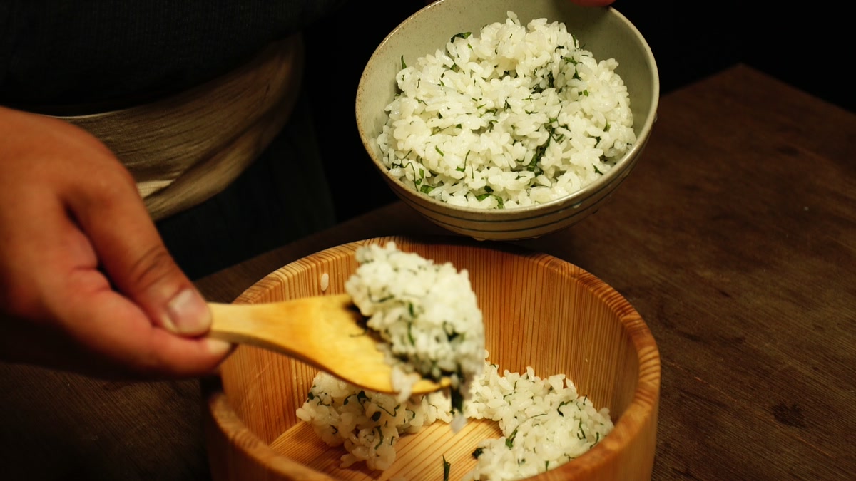 刻んだ紫蘇を混ぜた飯を、しゃもじで椀によそっているところ