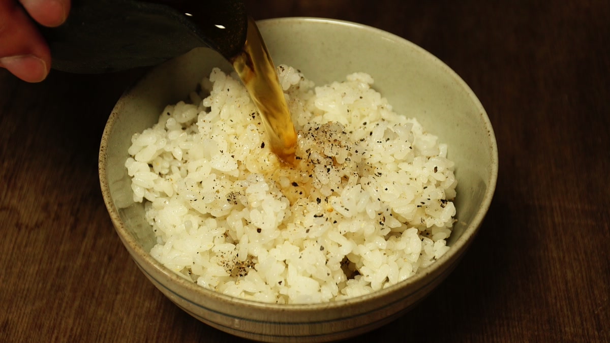 胡椒を混ぜた飯をよそった椀に、出汁を注いでいるところ